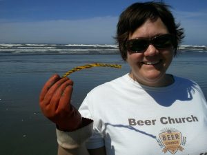 Kim holds up an example of one of the 10,000 little bits of yellow rope we will probably find on the beach again this year. Courtesy of the local "aquaculture" ratbastard litterbug seafood farmers.