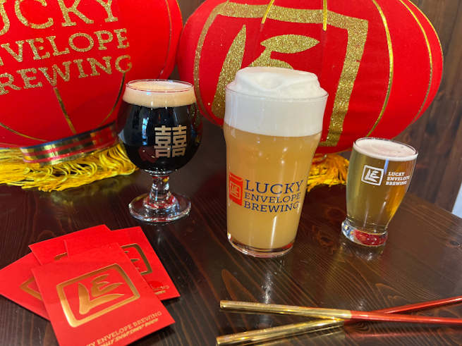 Glasses of beer and Chinese red envelopes announce the Lunar New Year celebration.