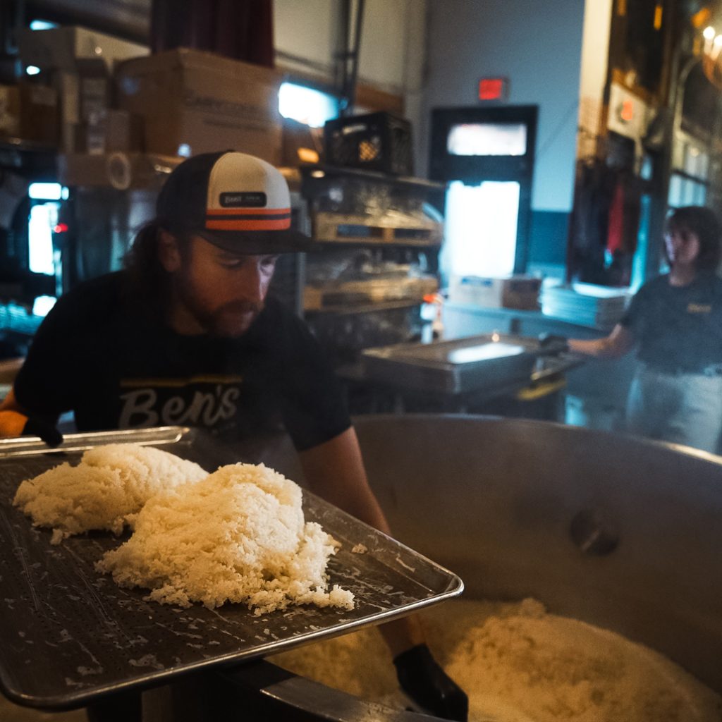 A brewer at High Wire Brewing working with rice.