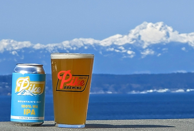 A pint of Pike Brewing's beer with mountains in the background.