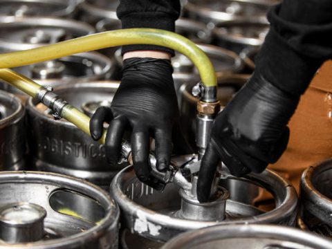 Hands putting taps on kegs.