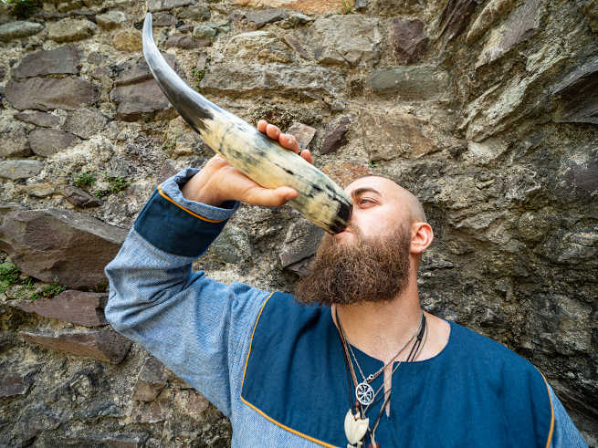 Viking drinking horns, a man drinking from one. 