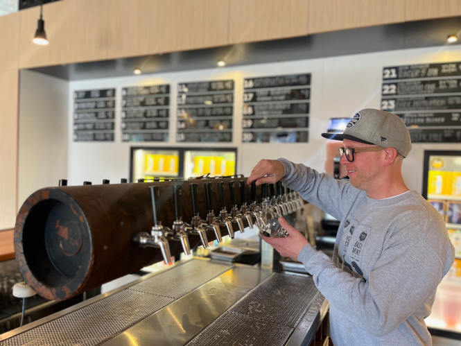 A bartender pouring a glass of cider at Seattle Cider Company.