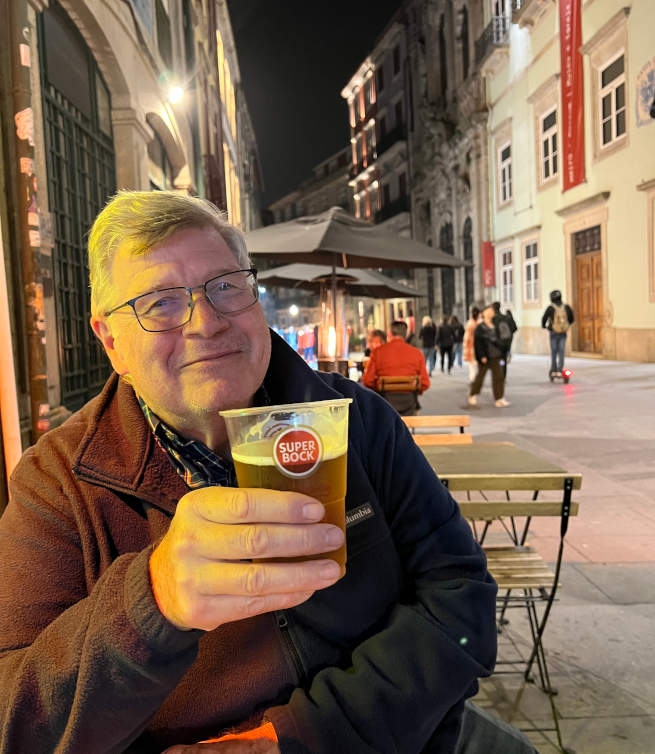 A person drinking a glass of Super Bock beer in Portugal