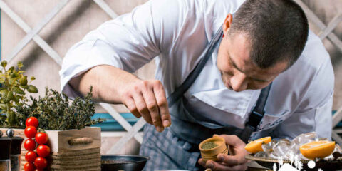 A chef carefully seasoning a dish