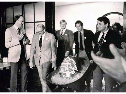 Men delivering the first keg of Redhook beer to a bar in a wheel barrow