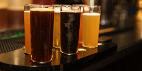A flight of craft beers in tall glasses on a Washington casino bar counter