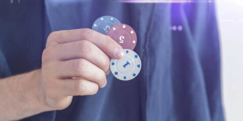 When Personalization Becomes Prediction: Can AI Stop Casino Addiction Before It Starts? Person holding colorful casino chips, symbolizing gambling behavior and how AI technology could help prevent casino addiction.