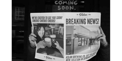 A person reading a newspaper against a black background