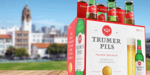 a six pack of beer on a wooden table.