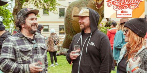 People laughing and sharing beers at a festival