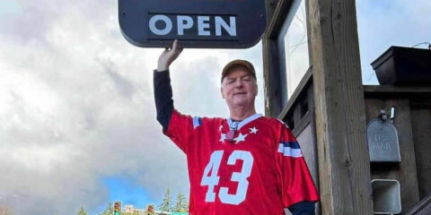 A man in a football jersey in front of a brewpub