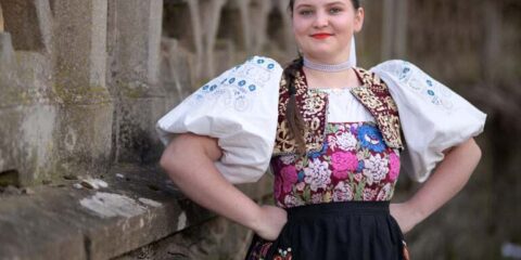 Woman standing confidently in a traditional Dirndl dress.