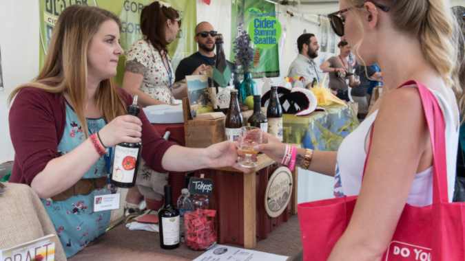 A person serving cider at a cider festival