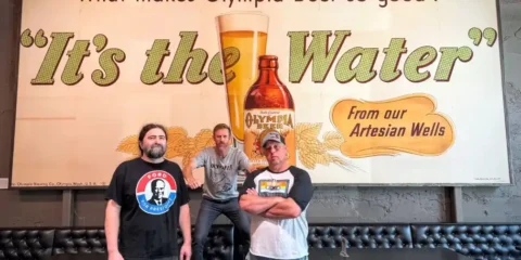 Leotucky Lager: a South Sound Mashup 130 Years in the Making Three men in front of a historic beer billboard