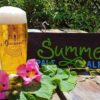 A pint of beer on a table with some wild flowers spread around it