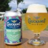 Chuckanut Brewery Colors Outside the Lines and Introduces a West Coast IPA A can of beer next to a glass of beer, sitting on a table outside with grass and trees in the background