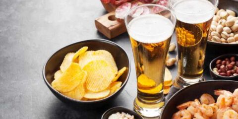 Pairing Local DC Brews with Catered Event Menus Glasses of craft beer served with shrimp, chips, nuts, and appetizers, representing local DC brews paired with catered event menu selections.
