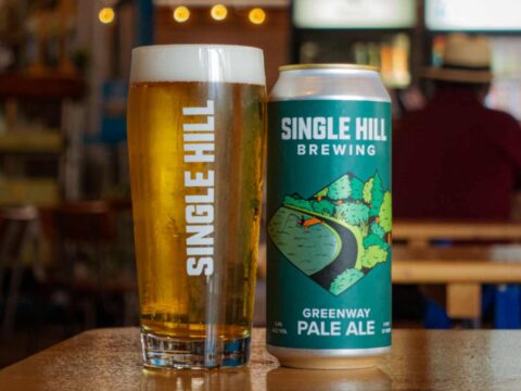 A can of beer sitting next to a freshly poured pint