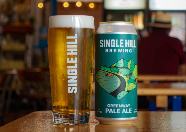 A can of beer sitting next to a freshly poured pint