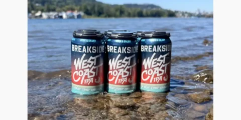 Breakside Defines West Coast IPA, and Frankly, They’ve Earned the Right To Six-pack of beer sitting in the shallows of a river