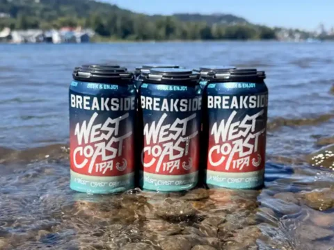 Breakside Defines West Coast IPA, and Frankly, They’ve Earned the Right To Six-pack of beer sitting in the shallows of a river