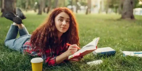 College student girl relaxing in a garden with a book while balancing study, hobbies, and social life.
