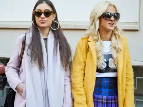 Two stylish women wearing fashionable outfits and sunglasses, illustrating how copying others’ style can be part of finding your own personal fashion identity.