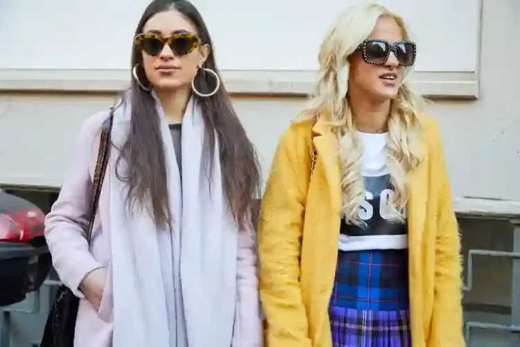 Why Copying Other People’s Style Is A Normal Part Of Finding Your Own Two stylish women wearing fashionable outfits and sunglasses, illustrating how copying others’ style can be part of finding your own personal fashion identity.
