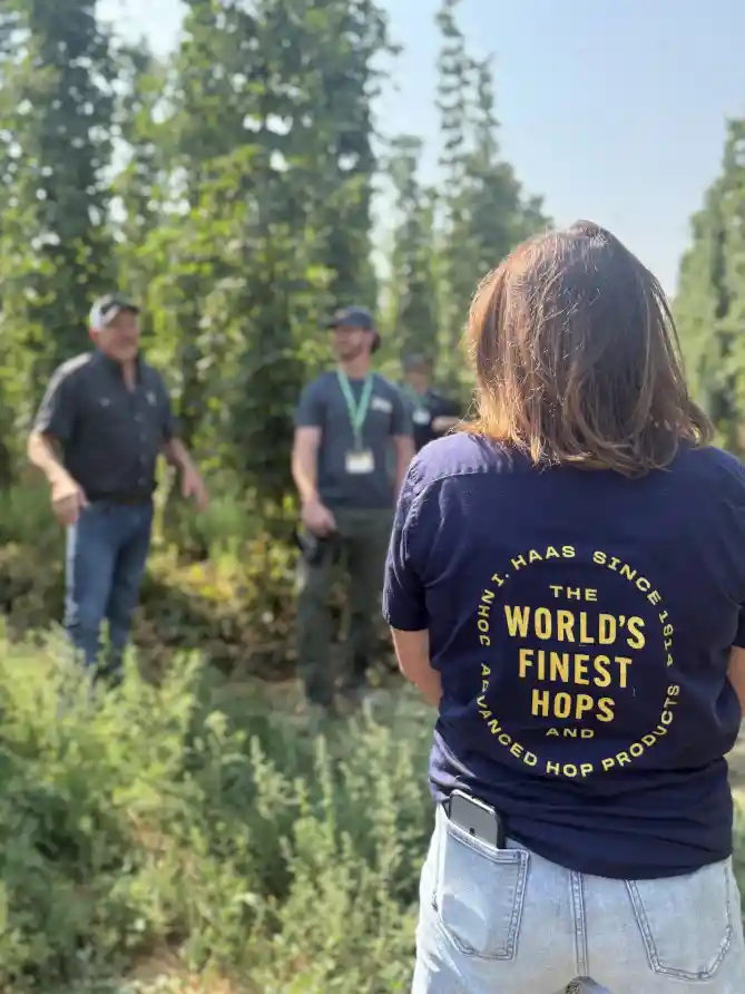 People standing and talking in a hop field.