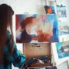 Why Hobbies And Social Activities Matter For College Students College student painting on a canvas in an art studio, illustrating how hobbies and social activities support student life and personal growth.