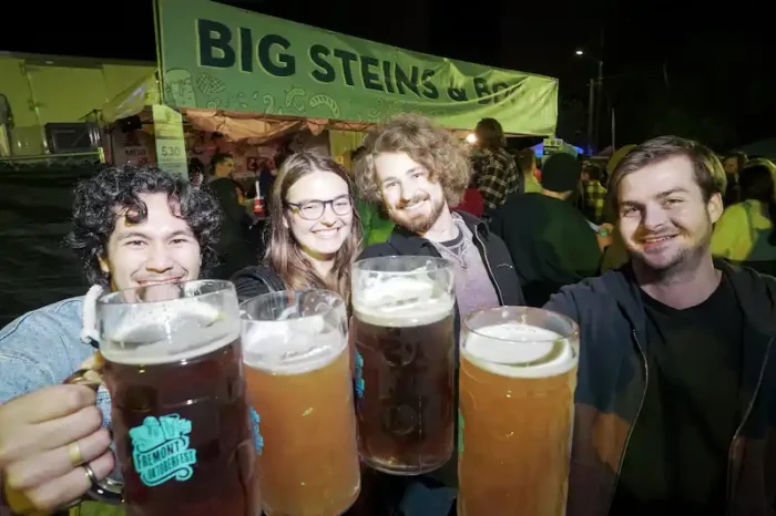 a group of friends hoisting mugs of beer