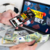 Top Sportsbook Software for Bookies: Risk Controls, Live Betting, and Provider Quality Person using sportsbook software for live sports betting with cash and sports equipment.
