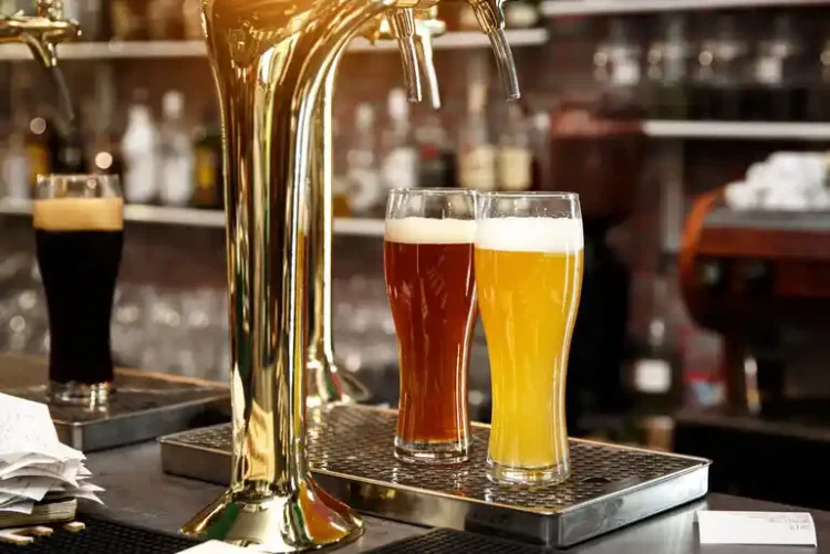 Why Non-Alcoholic Beer Is Harder on Draft Multiple beers being served from a draft system at a bar, highlighting the challenges of pouring non-alcoholic beer on draft.