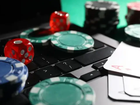 Live Dealer vs RNG Slots: Odds, Payouts, and Which One Suits You Best Live dealer casino game with poker chips, dice, playing cards, and computer keyboard representing RNG slots and casino games.