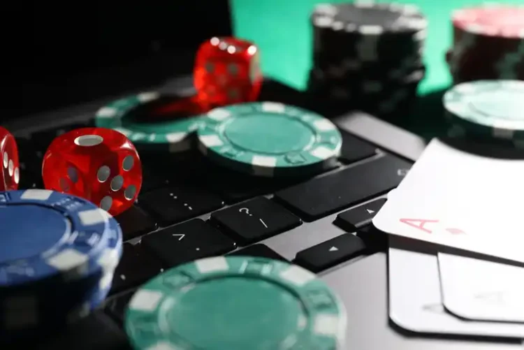 Live Dealer vs RNG Slots: Odds, Payouts, and Which One Suits You Best Live dealer casino game with poker chips, dice, playing cards, and computer keyboard representing RNG slots and casino games.