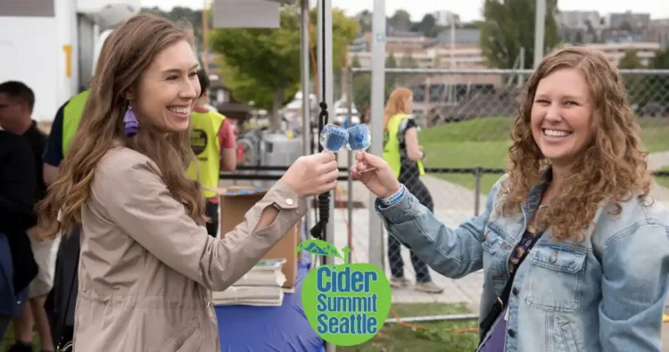 Two friends enjoying cider at a festival