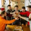 Friends raising beer glasses together at a brewery club gathering.