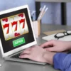 How to Play Golden 777 Slot for Real Money: Rules, Symbols and Free Spins A Man using a laptop to play an online casino game at home.