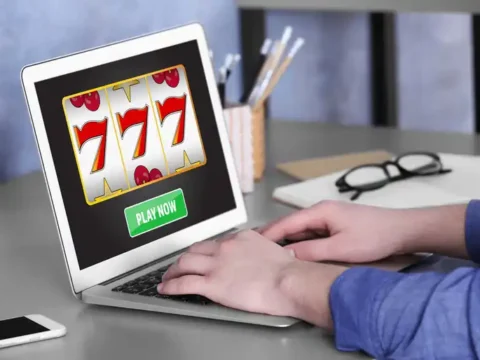 How to Play Golden 777 Slot for Real Money: Rules, Symbols and Free Spins A Man using a laptop to play an online casino game at home.