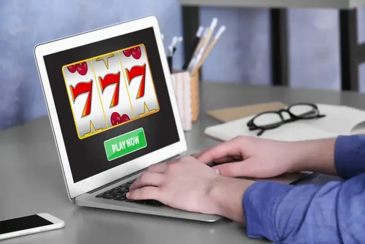 How to Play Golden 777 Slot for Real Money: Rules, Symbols and Free Spins A Man using a laptop to play an online casino game at home.