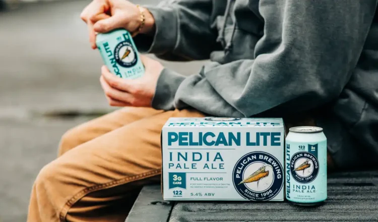 A person opening a can of Pelican Lite IPA