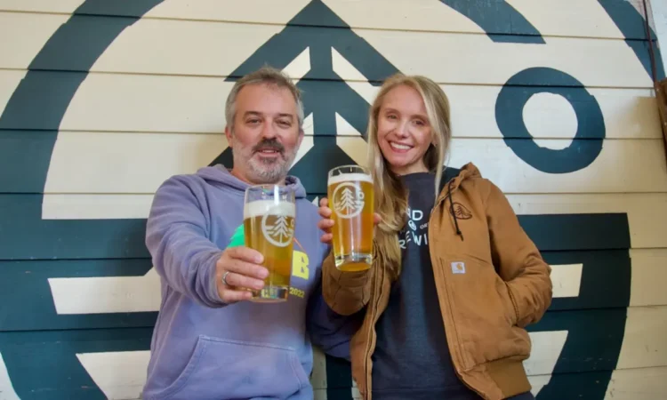 Two people hoisting pints of beer