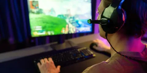 Man playing a video game on a PC while improving his online gaming skills.