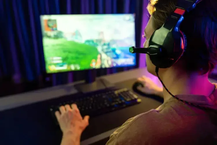 Man playing a video game on a PC while improving his online gaming skills.