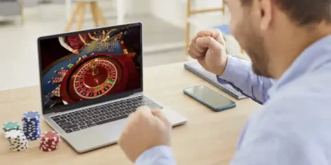 5 Mistakes to Avoid When Playing Live Roulette Online for the First Time Man playing live online roulette while poker chips on the table reacts joyfully.