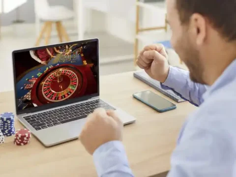 5 Mistakes to Avoid When Playing Live Roulette Online for the First Time Man playing live online roulette while poker chips on the table reacts joyfully.