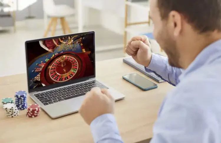 5 Mistakes to Avoid When Playing Live Roulette Online for the First Time Man playing live online roulette while poker chips on the table reacts joyfully.